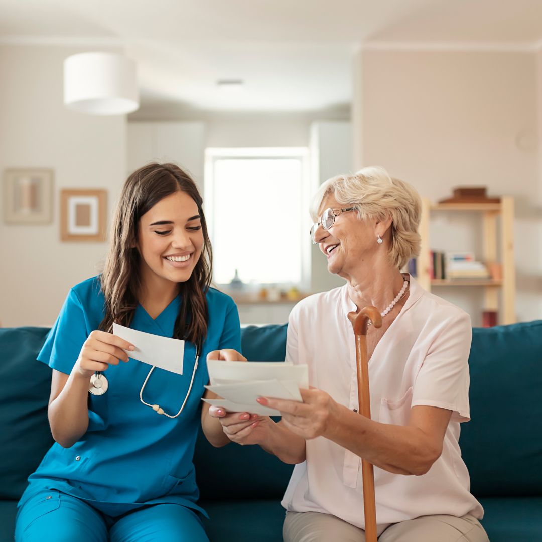 A female nurse looking at cards with an elderly woman.