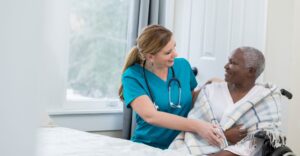 A female nurse assisting an elderly woman.