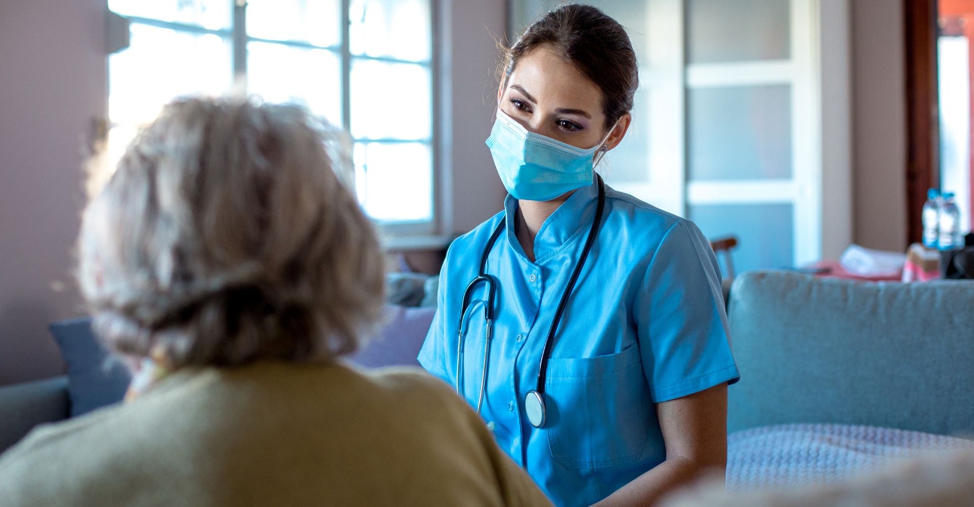 A female nurse looking compassionately at a patient.