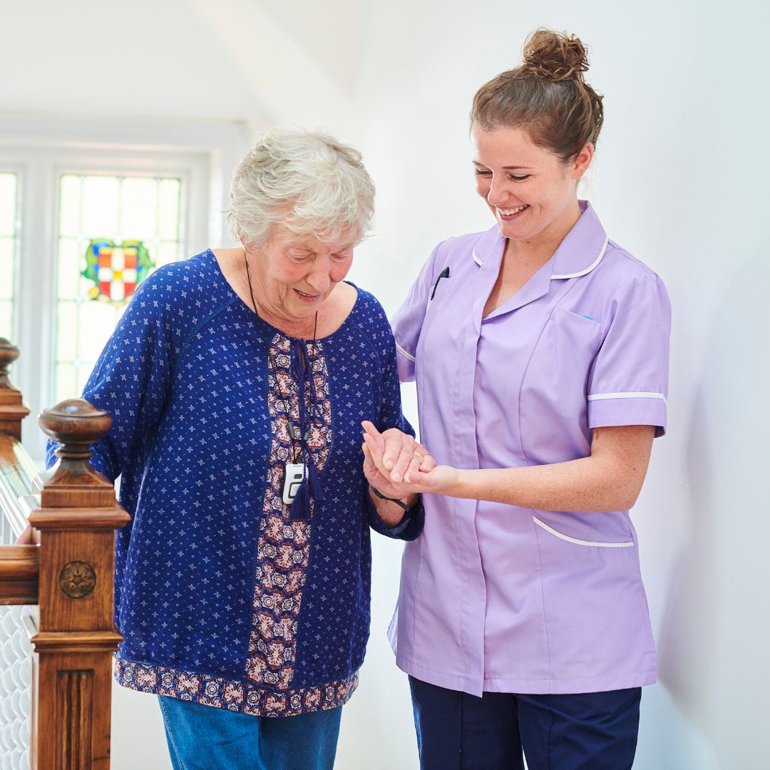 A female nurse helping an elderly woman walk.