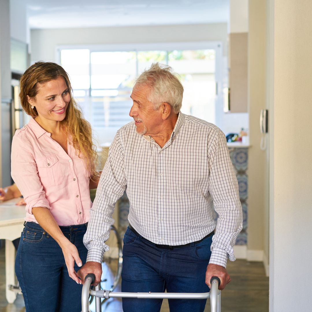 Woman helping man with his walker