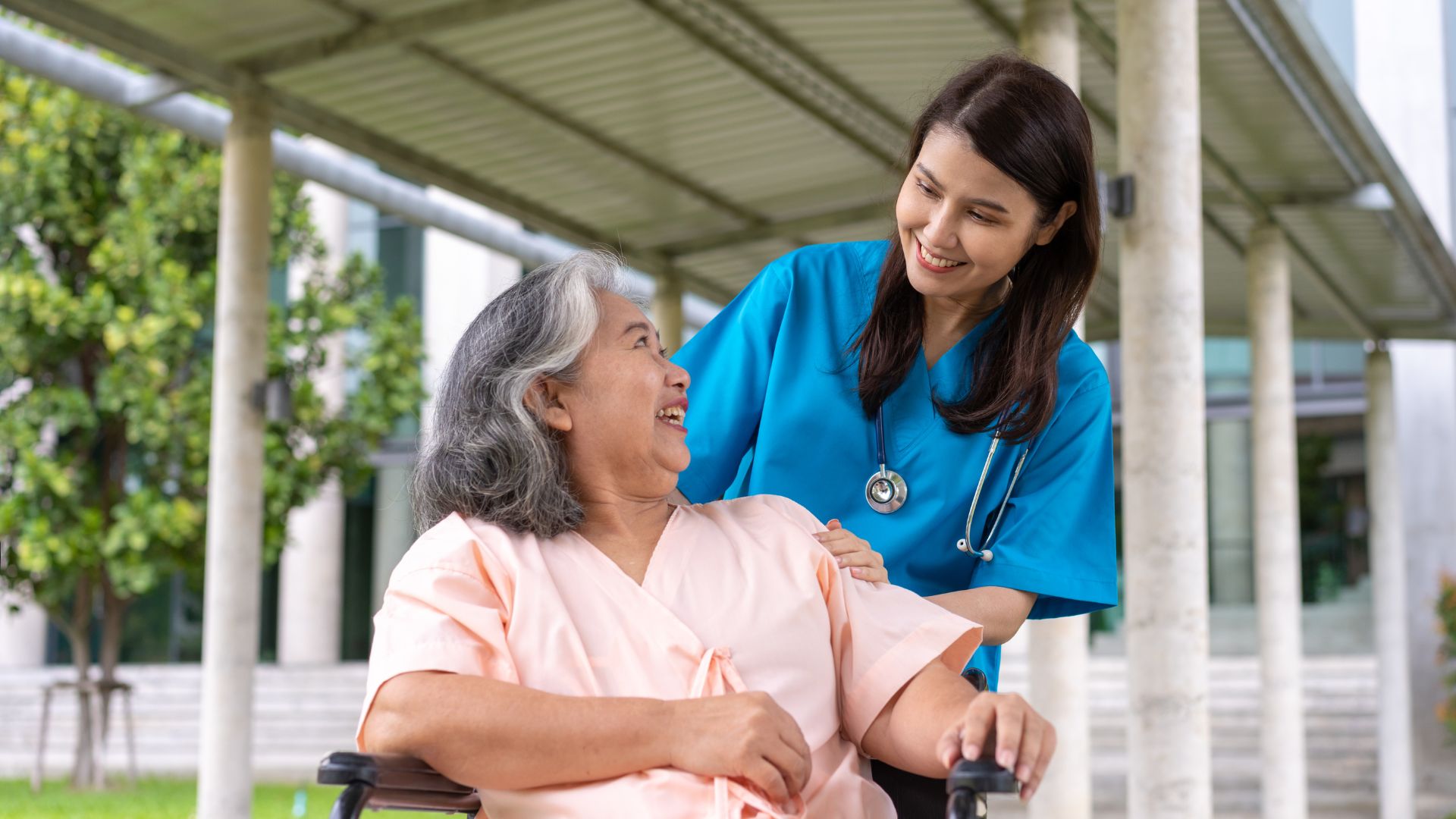 Nurse pushing a wheelchair with an elderly woman in it