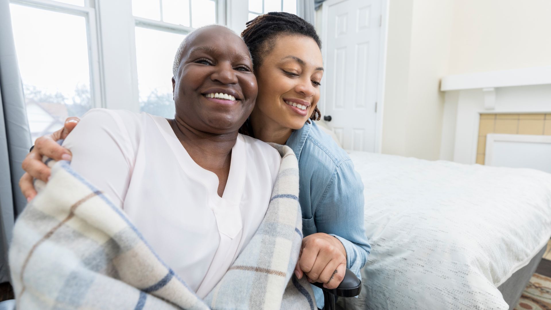 Elderly woman hugging senior care nurse